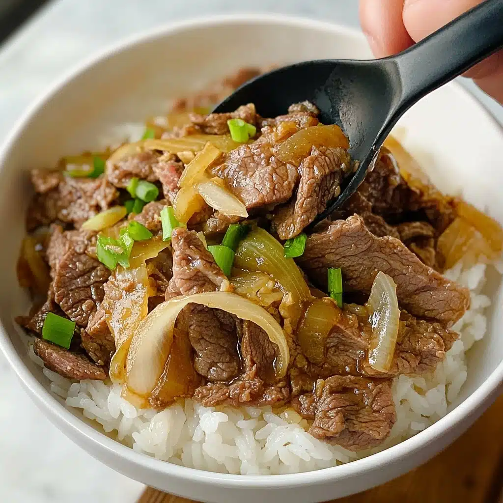 Gyudon Japanese Beef Rice Bowl, Japanese Beef Rice Bowl recipe, authentic Gyudon, quick Japanese dinner, easy Japanese beef bowl A white bowl filled with a layer of white rice at the bottom, topped with a mix of thin slices of cooked brown beef and translucent cooked onion pieces, with some light green scallion pieces scattered on top. A black spoon is scooping some of the beef and onion mixture, and a woman's hand is holding the bowl from the side. The background shows a white marbled surface.