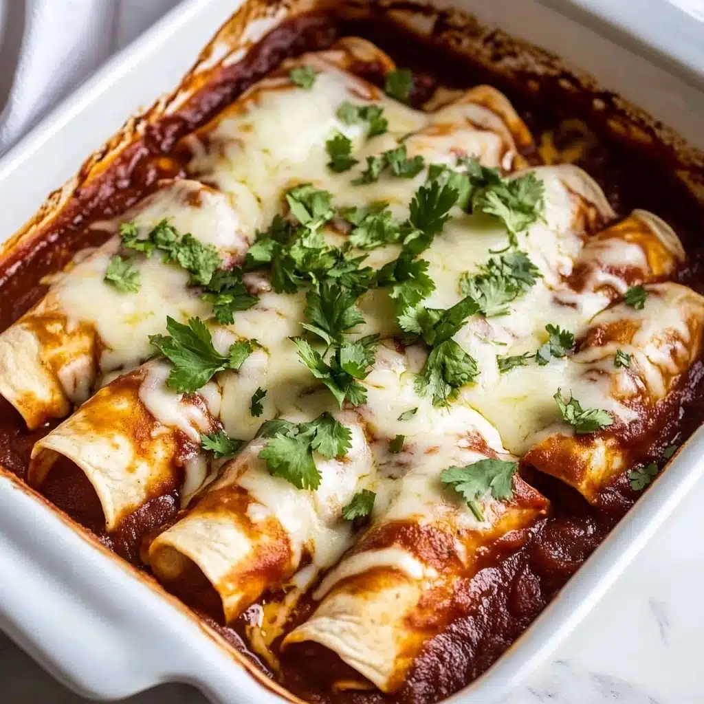 Beef Enchiladas, homemade enchiladas, beef enchiladas recipe, Mexican beef casserole, cheesy beef enchiladas The image shows a white baking dish filled with five rolled tortillas covered in a dark red sauce. The tortillas are tightly packed in the dish, their edges slightly browned. On top, there is a layer of melted white cheese that looks soft and stringy, spreading unevenly over the sauce and tortillas. Fresh green chopped cilantro is sprinkled over the cheese, adding a bright contrast. The dish is placed on a white marbled surface, with a white cloth visible to the side.