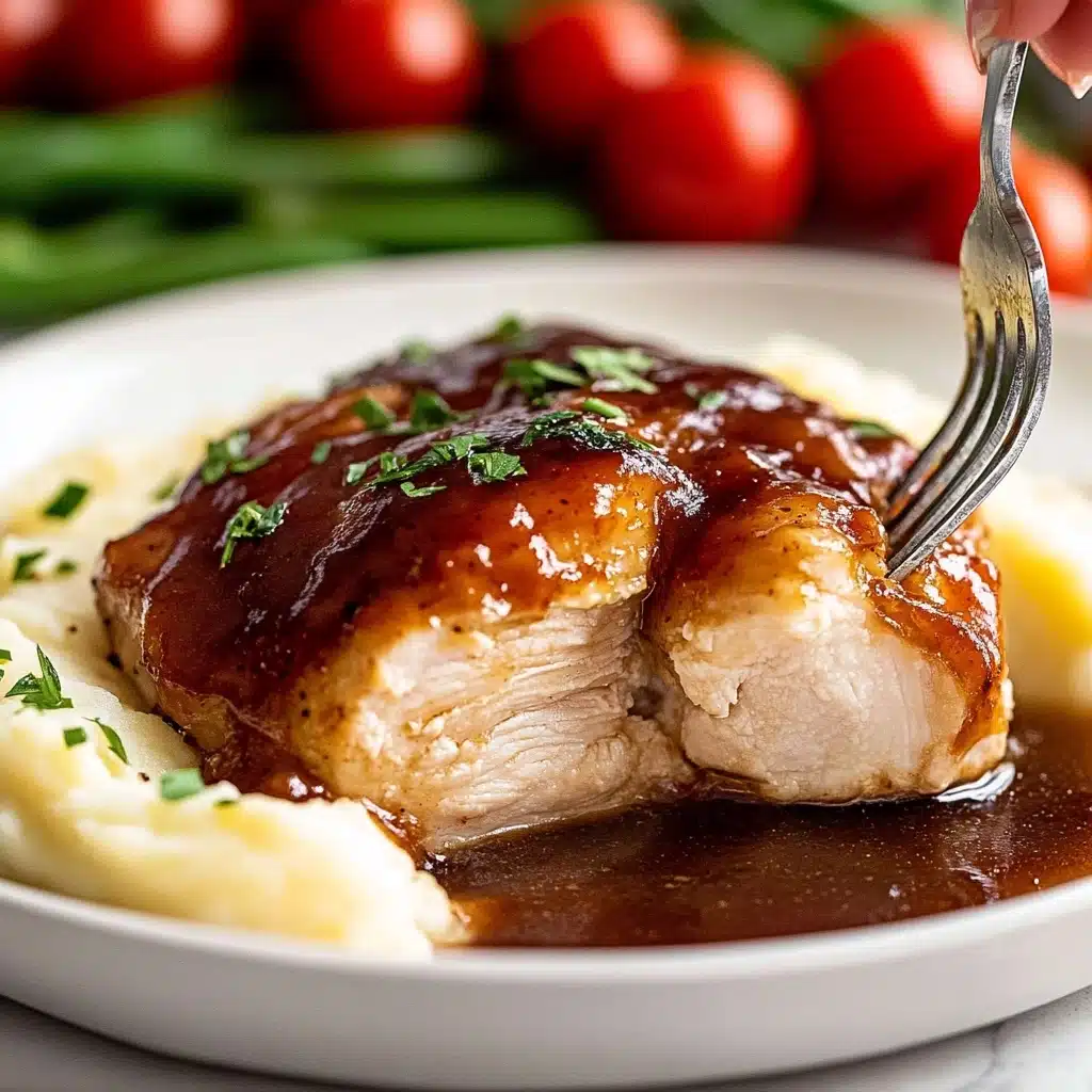 Oven Baked BBQ Chicken, Quick homemade barbecue sauce, Easy BBQ chicken recipe, Juicy oven baked chicken, Smoky grilled flavor without a grill A close-up view of a white plate with a thick, glossy dark brown sauce-covered piece of cooked chicken with a tender, white inside, placed over a creamy textured layer of mashed potatoes that have a pale yellow color, next to blurred background of bright red cherry tomatoes with green stems and green beans, a woman's hand holds a fork piercing a piece of chicken on the right edge of the plate; the sauce glistens and small green herb pieces are sprinkled on top of the chicken, all set on a white marbled surface,