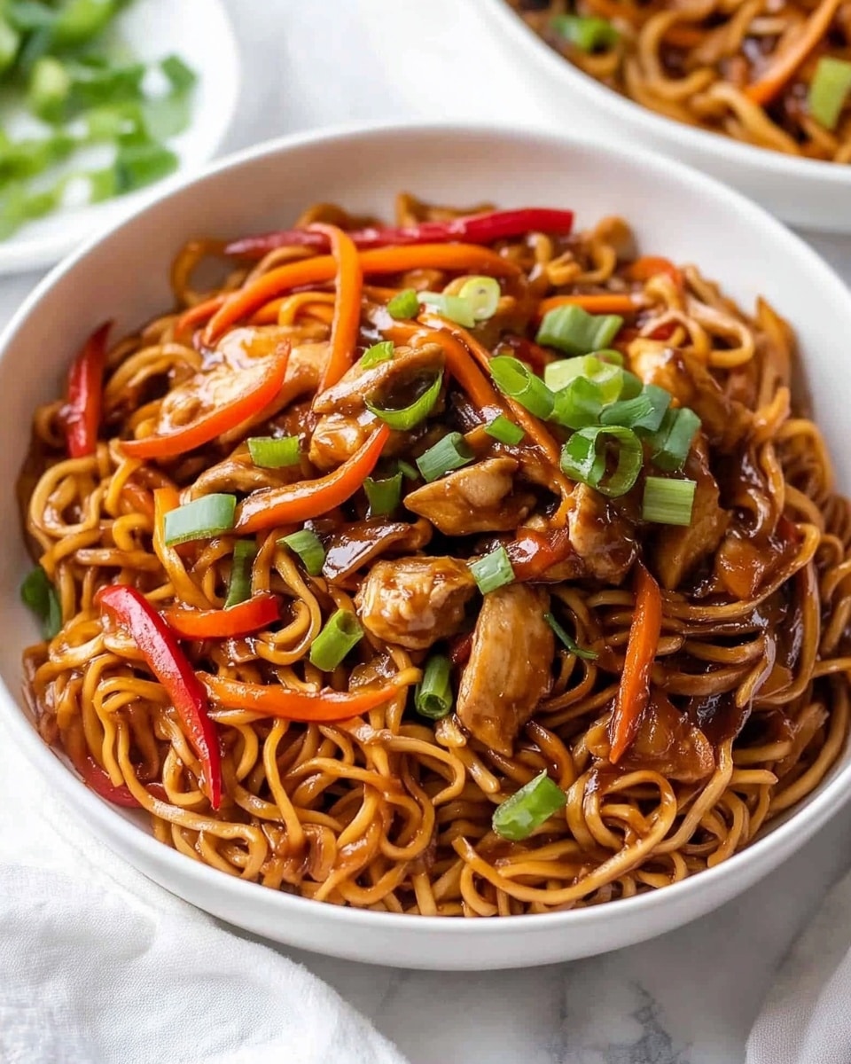 A white bowl filled with stir-fried noodles mixed with dark brown sauce, with visible red bell pepper strips, orange carrot thin strips, and small green onion rings scattered throughout. Chunks of browned meat are mixed in evenly. A silver fork is placed in the bowl, partially lifting some noodles on the right side. In the background, there are two white bowls, one with more noodles and the other with sliced green onions. The scene is set on a white marbled surface with a white cloth near the bowl. Photo taken with an iphone --ar 4:5 --v 6.1