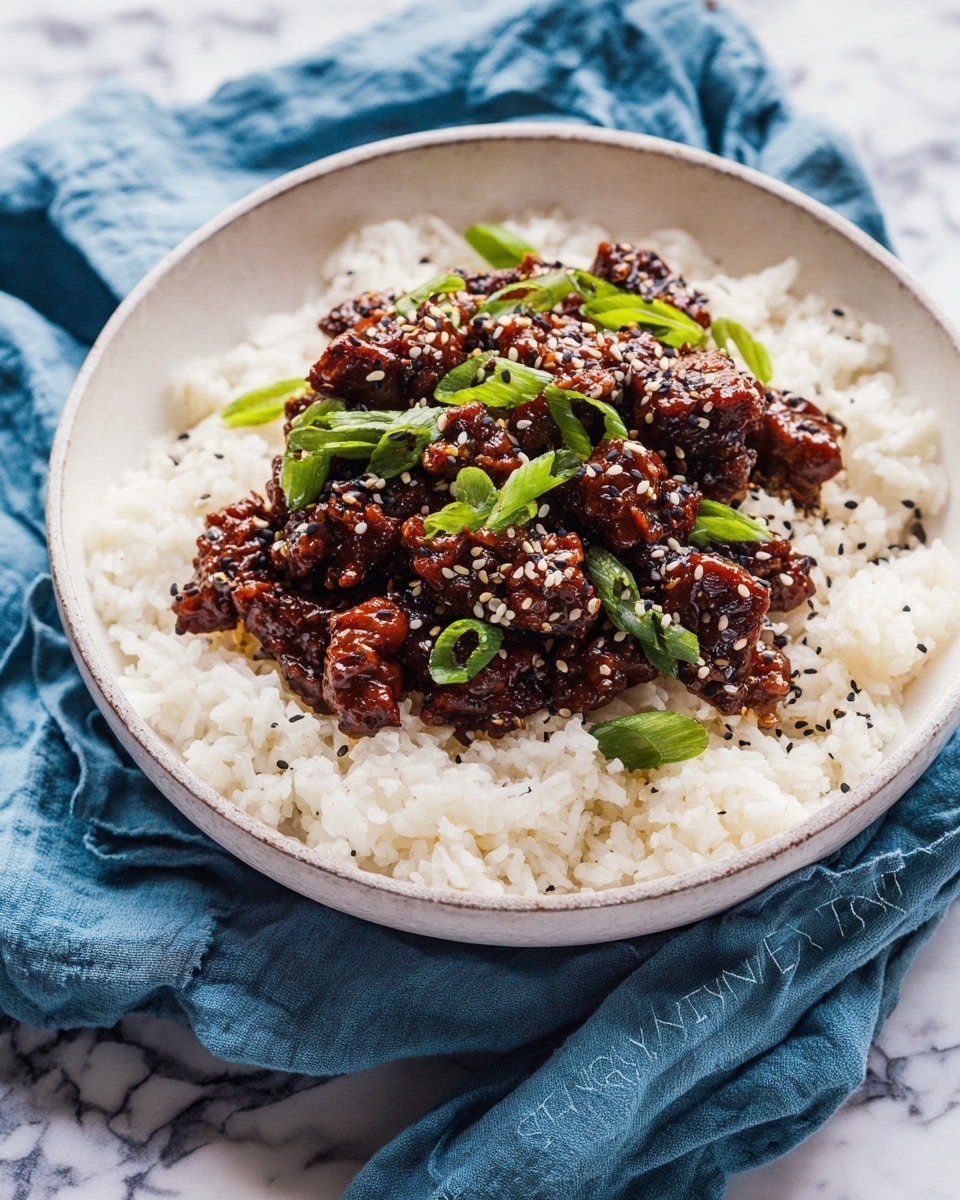 A white bowl filled with two layers: the bottom layer is plain white rice, fluffy with separate grains, covering the entire bowl; the top layer consists of dark brown glazed meat chunks mixed with small black and white sesame seeds, with bright green sliced scallions scattered over the meat. The bowl rests on a crumpled blue cloth, and the background is a white marbled surface. photo taken with an iphone --ar 4:5 --v 7