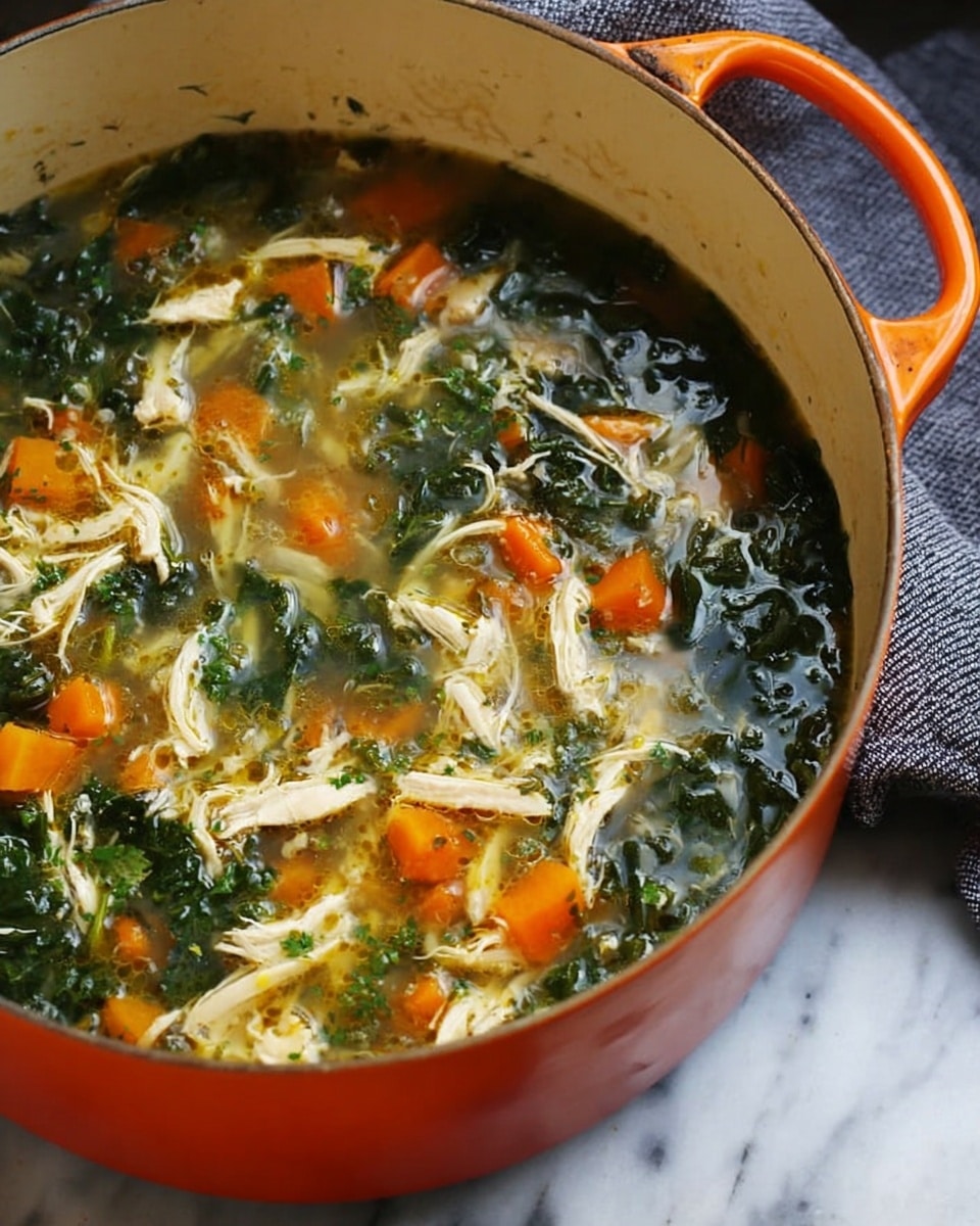 A close-up of a large orange pot filled with soup. The soup has three main visible layers: shredded white chicken pieces scattered throughout, bright orange chunks of carrot, and dark green leafy vegetables all mixed in clear broth. The pot sits on a white marbled surface with a gray cloth towel beside it. The photo taken with an iphone --ar 4:5 --v 7