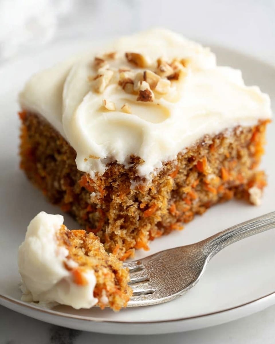 A single square piece of carrot cake sits on a white plate, showing three main layers: the bottom cake layer is brown with visible orange bits of shredded carrot and a soft, crumbly texture; on top is a thick, smooth layer of creamy white frosting that slightly drips over the sides of the cake; the background shows a white marbled surface with two orange carrots blurred in the distance. Photo taken with an iphone --ar 4:5 --v 7
