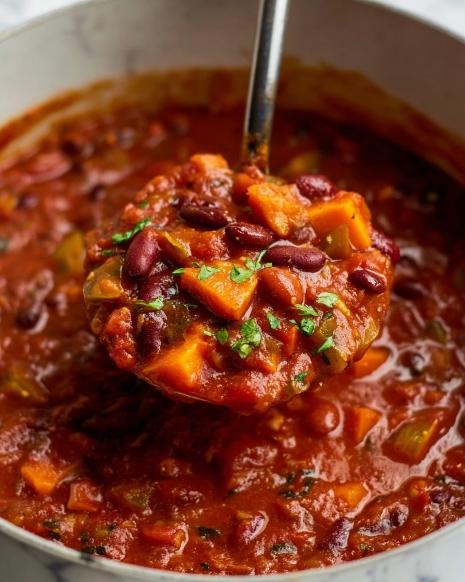 A close-up view of a stew filled with rich, chunky layers. The bottom layer consists of a thick red tomato-based sauce, speckled with small bits of green herbs and a glossy sheen. On top, there are large pieces of orange carrot, dark red kidney beans, light tan beans, and soft onion chunks mixed evenly throughout. The textures range from smooth sauce to firm vegetables and beans. A ladle is scooping a large portion, showing all layers mixed together, with some fresh green herbs sprinkled on top. The background is a white marbled texture. photo taken with an iphone --ar 4:5 --v 7