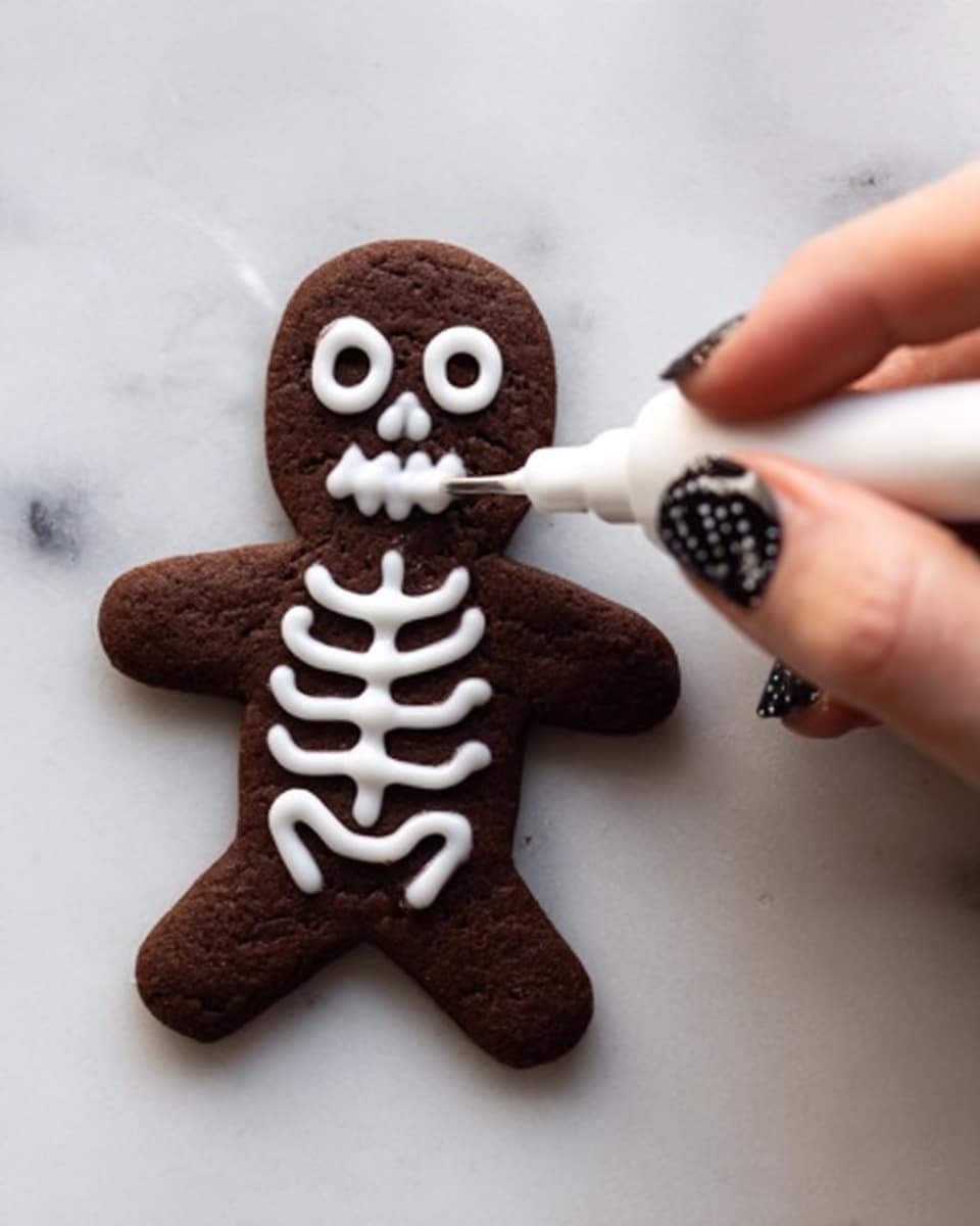 The image shows several cookies shaped like gingerbread people, covered in dark chocolate with white icing forming smiling faces, buttons, and decorative lines. The cookies are arranged close together on a white plate, which sits on a white marbled surface. The chocolate coating is smooth and shiny, while the white icing lines add texture and contrast. Each gingerbread person is fully coated in chocolate except for the white icing details on top. photo taken with an iphone --ar 4:5 --v 7