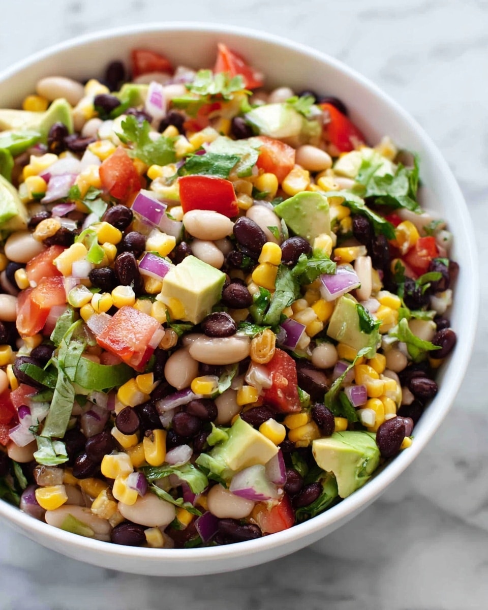 A close-up view of a white bowl filled with a colorful mixed salad having three visible layers: the top layer shows yellow corn kernels and black beans with shiny textures, the middle layer has small chopped pieces of red tomatoes and green avocado giving a fresh look, and the bottom layer contains diced purple onions and green herbs, adding more color contrast. The bowl is placed on a white marbled surface, and there is a blurred background of green leaves and some bread. The lighting is bright and natural, making the colors pop photo taken with an iphone --ar 4:5 --v 7