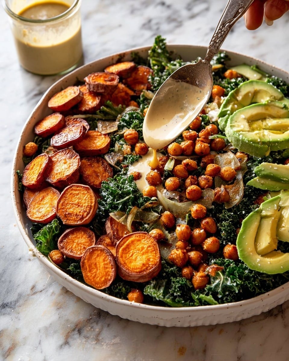 A large white bowl holds a colorful salad with three main layers. The first layer is dark green chopped kale spread evenly at the bottom, with some pieces having a curly texture. On top, there are round slices of roasted sweet potato, a burnt orange color, scattered around the bowl in clusters. Interspersed with these are many small, round, golden-brown roasted chickpeas, adding a crunchy texture throughout. There are also thick slices of light green avocado placed evenly, adding softness to the dish. A woman's hand is holding a spoon with light beige dressing being poured over the salad. The bowl sits on a white marbled surface, with a small glass jar of the same dressing placed nearby. Photo taken with an iphone --ar 4:5 --v 7