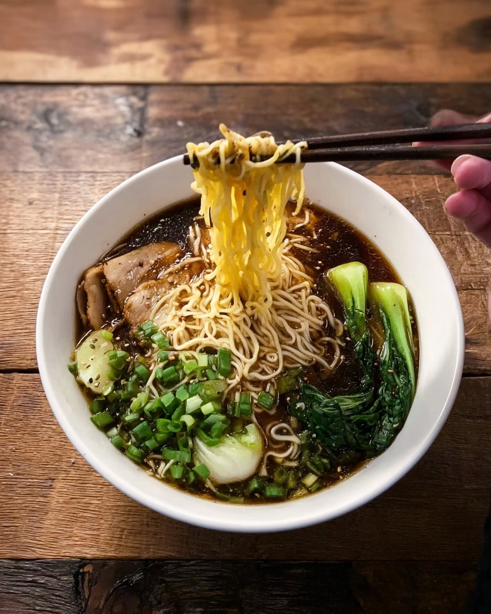A white bowl filled with dark broth holds several layers: at the bottom are thin yellow noodles being lifted up by a woman's hand holding dark chopsticks, above the noodles are slices of light-colored meat on one side, and bright green vegetables with a slightly charred texture on the other side. The bowl is placed on a wooden surface. Photo taken with an iphone --ar 4:5 --v 7