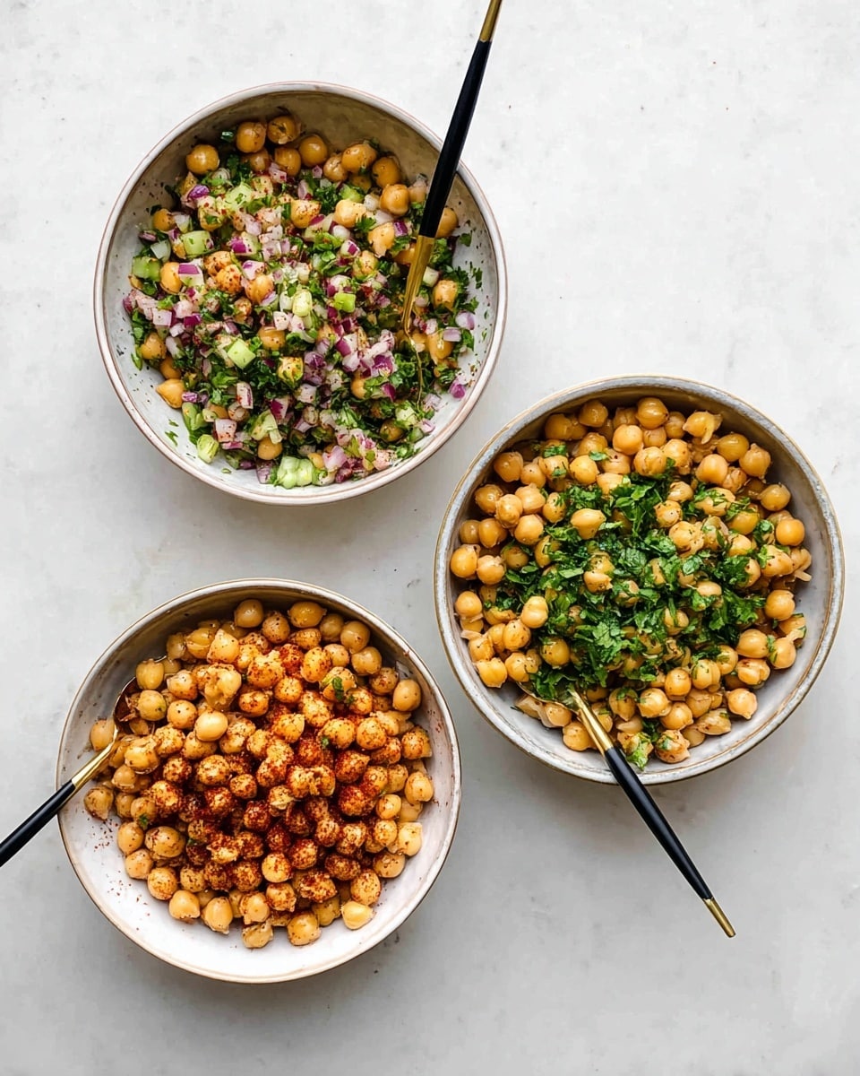The image shows six white bowls and plates arranged on a white marbled surface. The largest bowl at the top left contains light yellow spiral pasta topped with a layer of cooked chickpeas mixed with a red sauce. Below it, another bowl is filled with plain chickpeas mixed with green herbs and bits of red onion, with a spoon inside. To the left, a bowl has plain chickpeas mixed with chopped green herbs and a spoon resting in it. At the center right, a bowl holds a mix of crispy pita chips, green leafy arugula, cucumber slices, and chickpeas with herbs. On the bottom right, a plate has a base layer of white cheese topped with a small helping of chickpeas cooked in red sauce, and several triangular pita chips placed around it. At the top right, a white plate holds a plain pita bread with a slight golden toasting on top, folded and filled with some green salad visible from the side. Photo taken with an iphone --ar 4:5 --v 7
