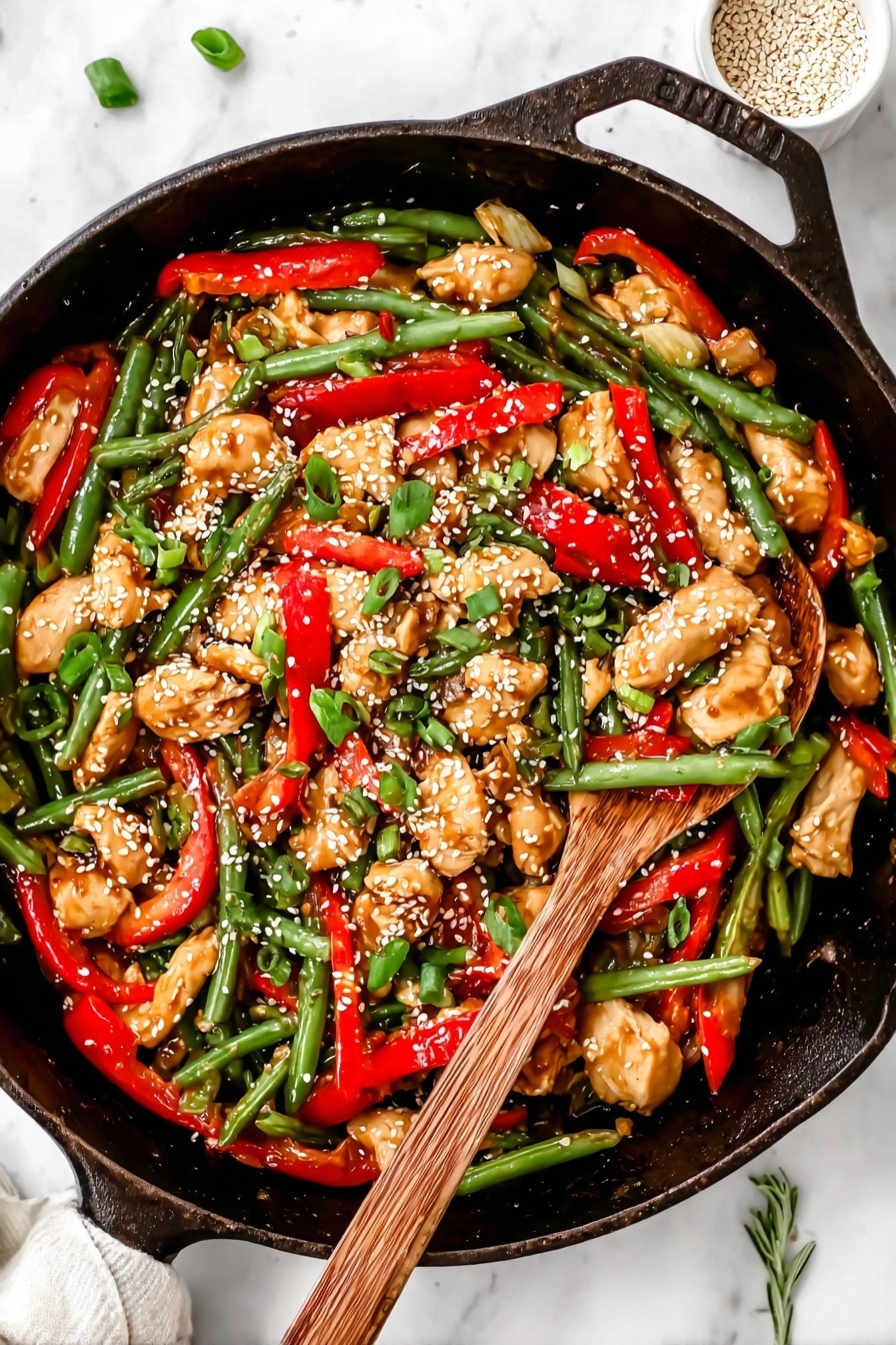 A black cast iron pan filled with a colorful stir-fry showing three main layers: the base layer has shiny, green beans with a fresh texture spread all around; the middle layer has bright red sliced bell pepper strips adding a pop of color mixed evenly; the top layer contains chunks of light brown cooked chicken pieces sprinkled with white sesame seeds and chopped green onions, giving it a fresh and textured look. On the right side, a wooden spoon with a natural grain rests inside the pan, partly covered by the food. The whole scene is set on a white marbled surface with a small white bowl of sesame seeds and a green herb sprig partially visible. Photo taken with an iphone --ar 2:3 --v 7 - Healthy Orange Chicken Stir Fry, healthy orange chicken recipe, nutritious chicken stir fry, easy vegetable stir fry, citrus chicken dinner